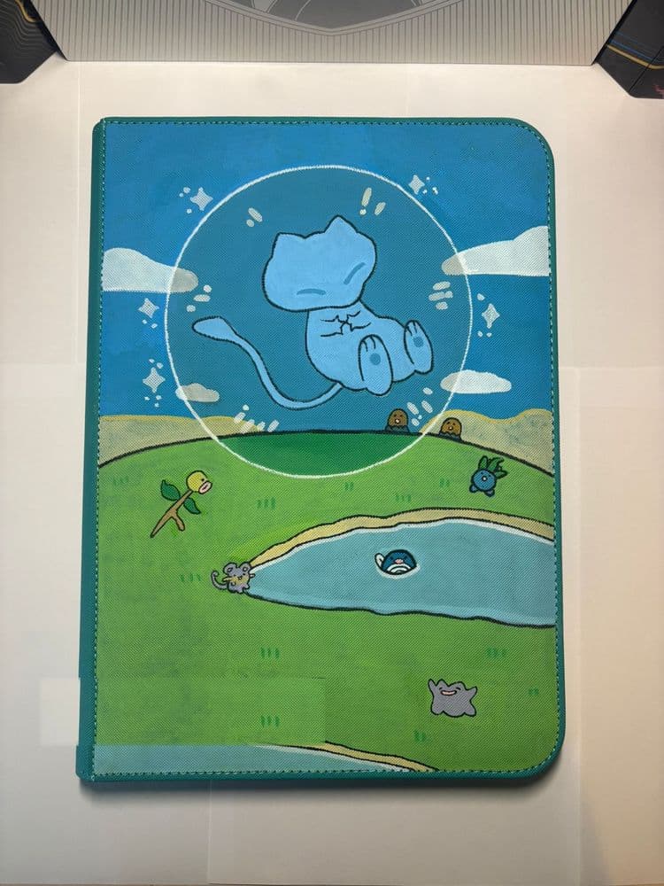 Custom binder met een slapende Mew in een luchtbel boven een dromerig pastellandschap