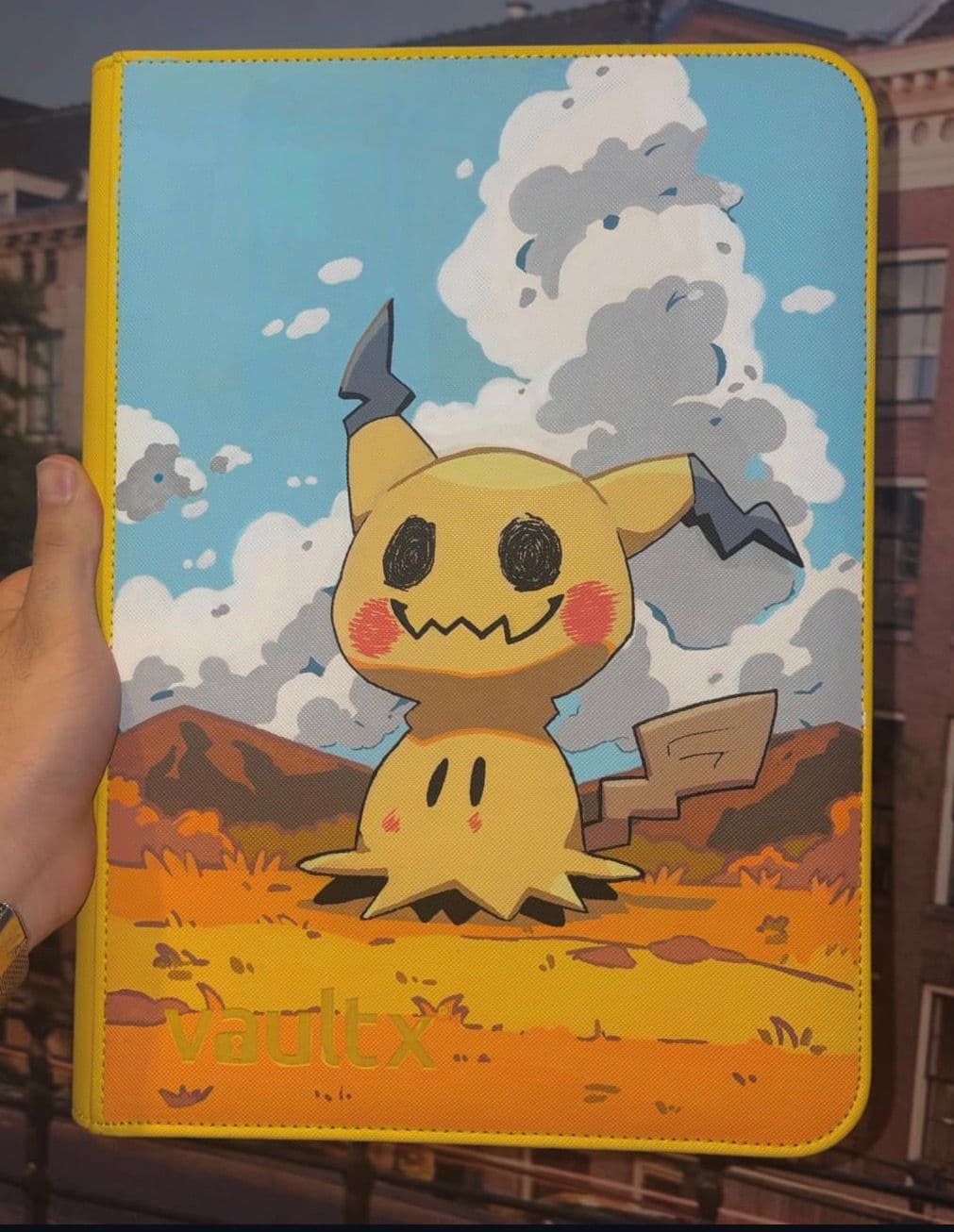 Custom Mimikyu-binder tegen een dromerige wolkenlucht